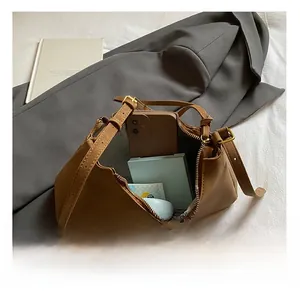 Top-down view of a brown leather shoulder bag interior with grey herringbone lining