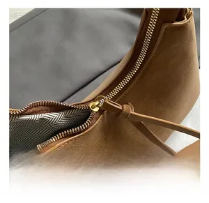 Detail of golden metal zipper closure with leather puller on a brown tote bag