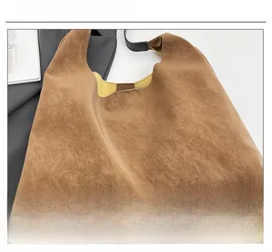 Detail shot of brown hobo tote bag featuring a vibrant yellow interior and black strap