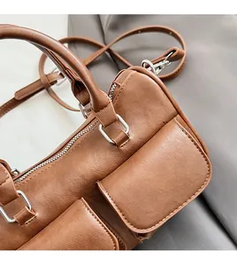 Close-up of brown litchi pattern PU leather handbag with silver buckles and flap pockets