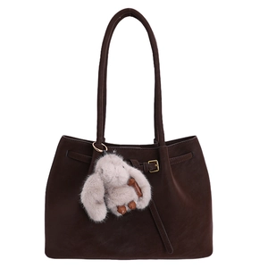 Dark brown suede tote bag featuring a decorative belt buckle and a plush rabbit pendant