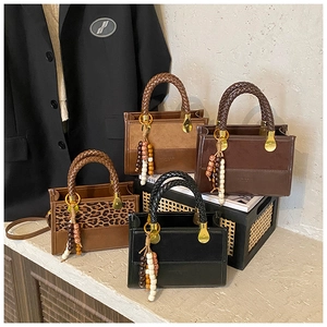 Detailed view of leopard print and solid mini bags with chunky woven handles and beads