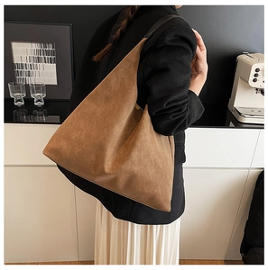 Detailed side view of a brown frosted hobo tote bag with black shoulder straps