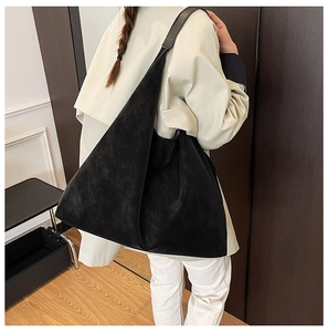 Minimalist black oversized tote bag worn by a model in a modern professional setting