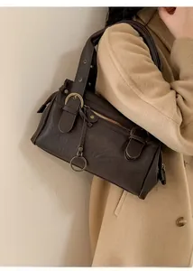 Détail d'un sac à bandoulière en similicuir marron foncé avec boucle et anneau métal