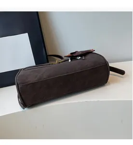Detail view of brown suede cylinder tote bag featuring high-quality metal lock closure