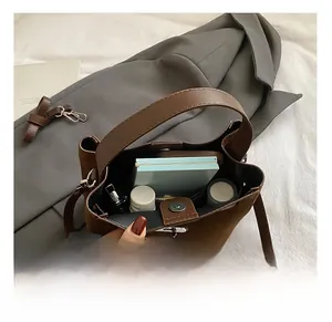 Vue de dessus montrant la capacité intérieure du sac seau en daim marron foncé pour rangement