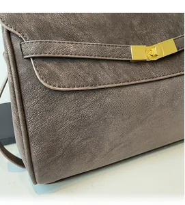 Detail of soft pebbled leather and golden twist lock on a vintage brown tote bag
