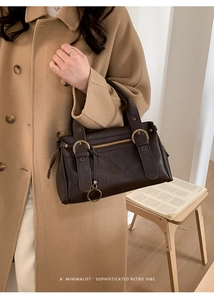 Détail du sac Boston en cuir marron foncé vintage avec boucles en bronze et fermeture éclair