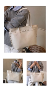 Close-up of beige tote bag with silver studs and decorative buckle detail