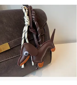 Detail of dachshund leather charm with woven rope attached to a brown tote bag