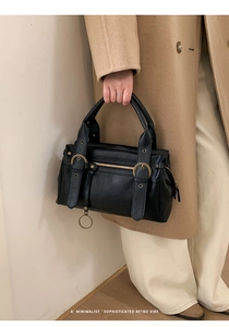 Détail du sac à main rétro noir avec ferrures en bronze antique et breloque anneau
