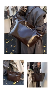 Detail view of large dark brown leather tote bag with silver rivets and long straps