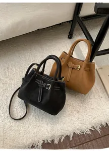 Detailed view of retro faux suede tote bags in black and brown with contrast stitching