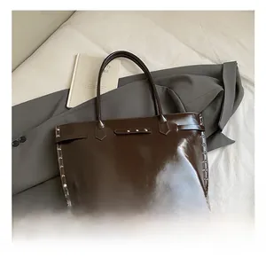 Detail view of the dark brown glossy oil wax leather tote bag with silver metal rivets