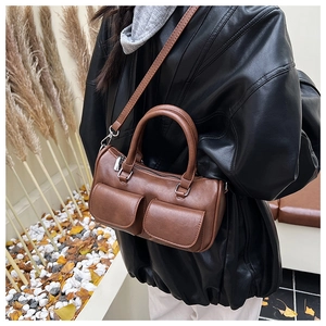 Detail of brown PU leather crossbody bag with dual outer pockets and adjustable strap