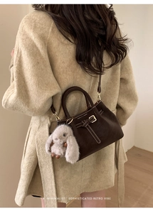 Detailed view of retro brown suede tote with leather buckle and plush bunny charm