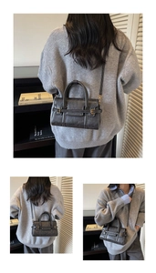 Close-up of contrast stitching and metal hardware on dark grey retro leather handbag