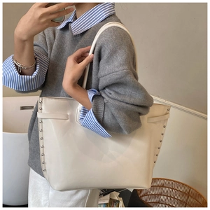 Mirror selfie showing large white tote bag with silver studs and long shoulder straps