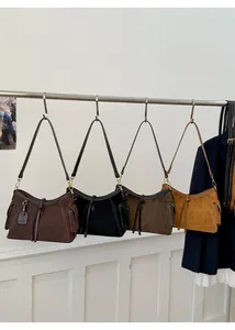 Detailansicht von vier Wildleder-Schultertaschen mit Kontrastnähten und Seitentaschen