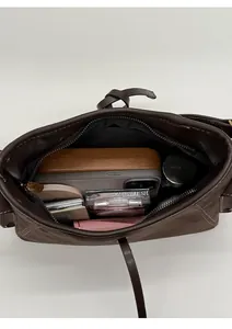 Top view showing the spacious interior of a brown suede shoulder bag with daily items