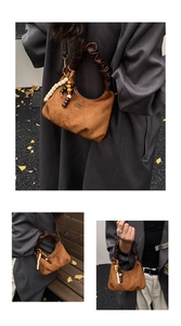 Close-up of brown suede dumpling bag with quilted texture and beaded charm detail