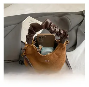 Detail view showing internal storage capacity of quilted brown suede dumpling bag