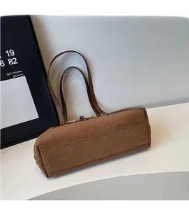 Detail showing the brown suede texture and neat stitching of the vintage shoulder bag