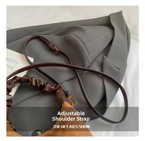 Detailed macro view showing the adjustable shoulder strap and vintage brown matte leather texture