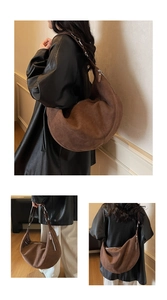 Dettaglio della fibbia in metallo e cuciture sulla grande borsa hobo in pelle scamosciata