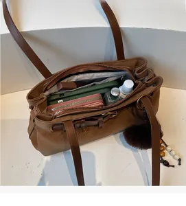 Internal view of the brown shoulder bag showing large capacity for phone and wallet