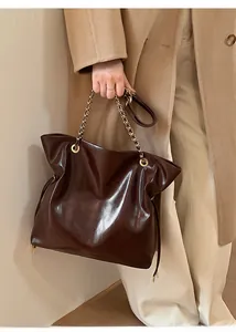 Détail du sac cabas en cuir ciré marron foncé avec chaîne dorée et cordon serrage