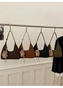 Detalle de bolsos tote de gamuza en cuatro colores con dijes de ositos de peluche