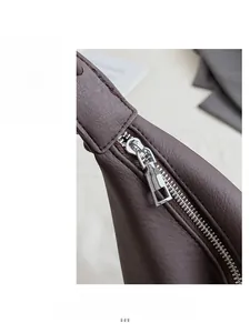 Close-up of smooth silver metal zipper on premium brown leather crossbody bag