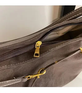 Detail of premium gold-toned zipper pull and smooth closing on brown vintage tote bag