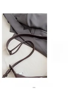Detail of soft dark brown leather shoulder strap and premium matte texture of the crossbody bag