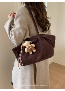 Brown suede tote bag detail featuring a cute bear plush pendant with SUYSP embroidery