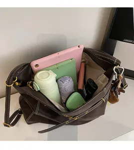Top view showing the spacious interior of a brown leather tote bag with various items