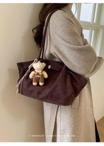 Detail of dark brown suede tote bag with a removable bear pendant and plush texture