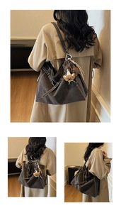 Detail of dark brown vintage tote bag with cute bear charm and adjustable strap