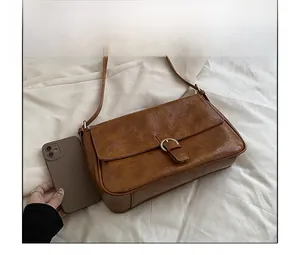 Detailed size comparison of the vintage brown faux leather shoulder bag with a smartphone