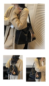 Macro detail of black leather tote bag with white stitching and bear plush charm