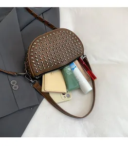 Detail of brown half-moon bag with silver rivets showing spacious interior storage