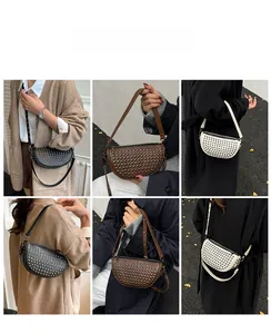 Detail view of crescent rivet bag in multiple colors shown on a model for styling