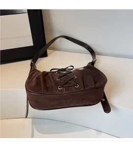 Close-up of the vintage dark brown suede underarm bag with cross strap ribbon details