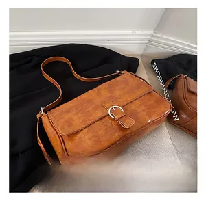 Detailed shot of caramel vintage leather shoulder bag with gold ring buckle and soft texture