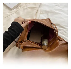 Detail of soft brown leather tote interior showing spacious capacity for phone and cosmetics