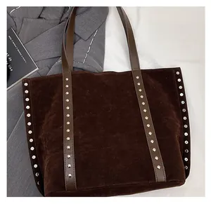 Detail view of large coffee brown suede tote bag with decorative silver rivets