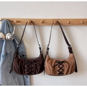 Detail of vintage suede shoulder bags with lace-up bow design in coffee and tan