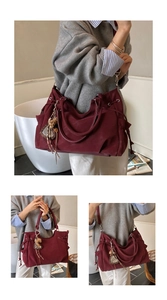 Detail of burgundy suede tote bag featuring drawstring closure and leopard heart charm